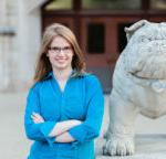 photo of Hannah Stigter standing next to the stone bulldog statue on Butler's campus